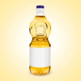 Image of Cooking oil in plastic bottle with empty label on light yellow background. Mockup for design