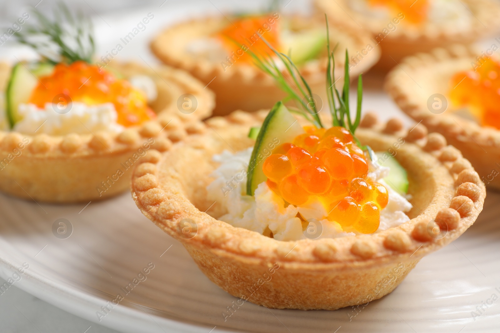 Photo of Delicious canapes with red caviar on plate, closeup