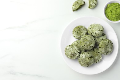 Photo of Plate with tasty matcha cookies and powder on white marble table, flat lay. Space for text