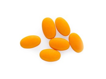 Photo of Tasty orange dragee candies on white background, top view