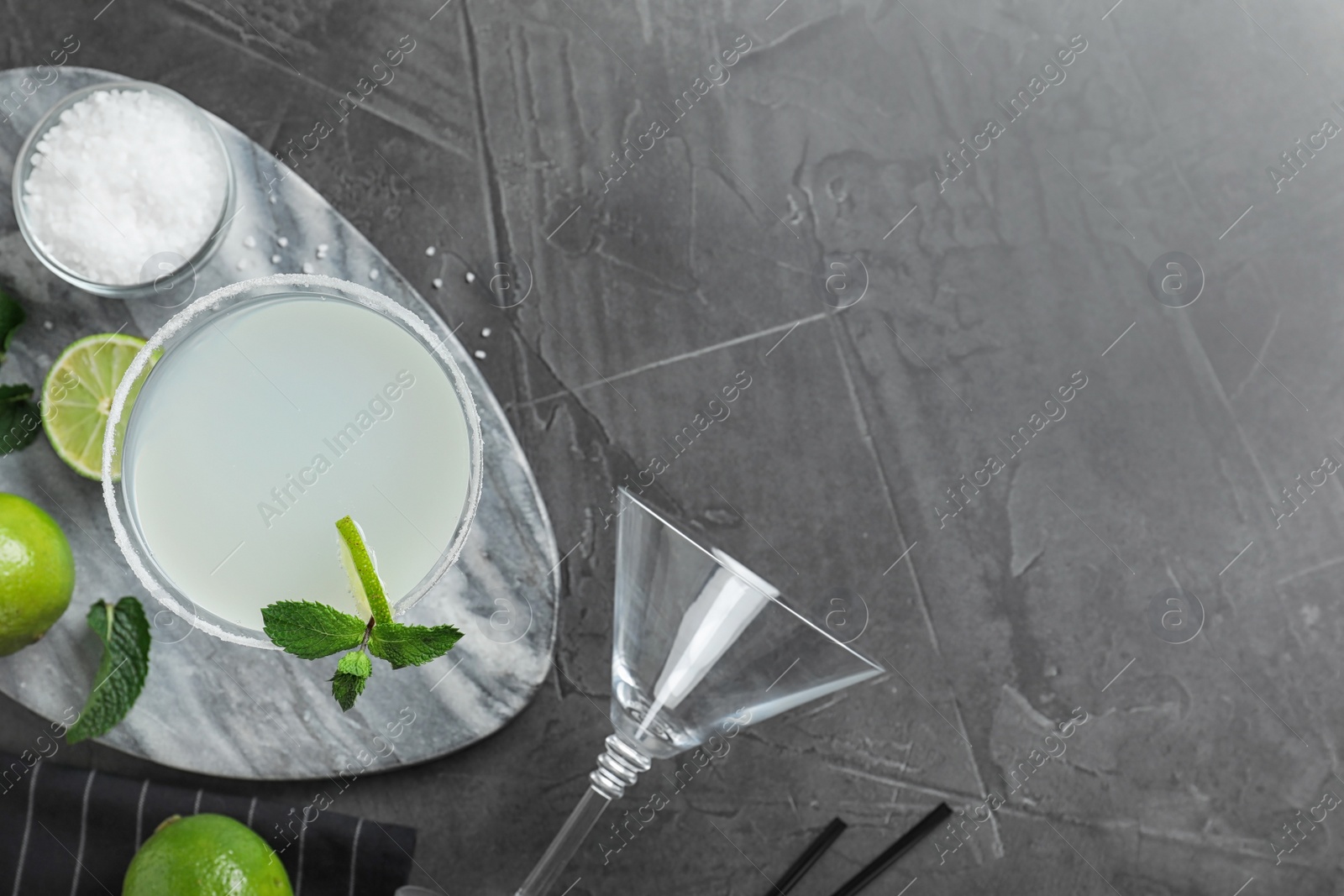 Photo of Flat lay composition with delicious cocktail on grey table. Space for text