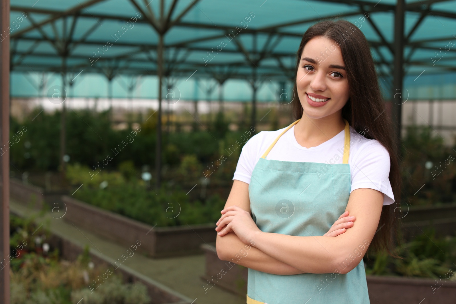 Photo of Female business owner in greenhouse. Space for text