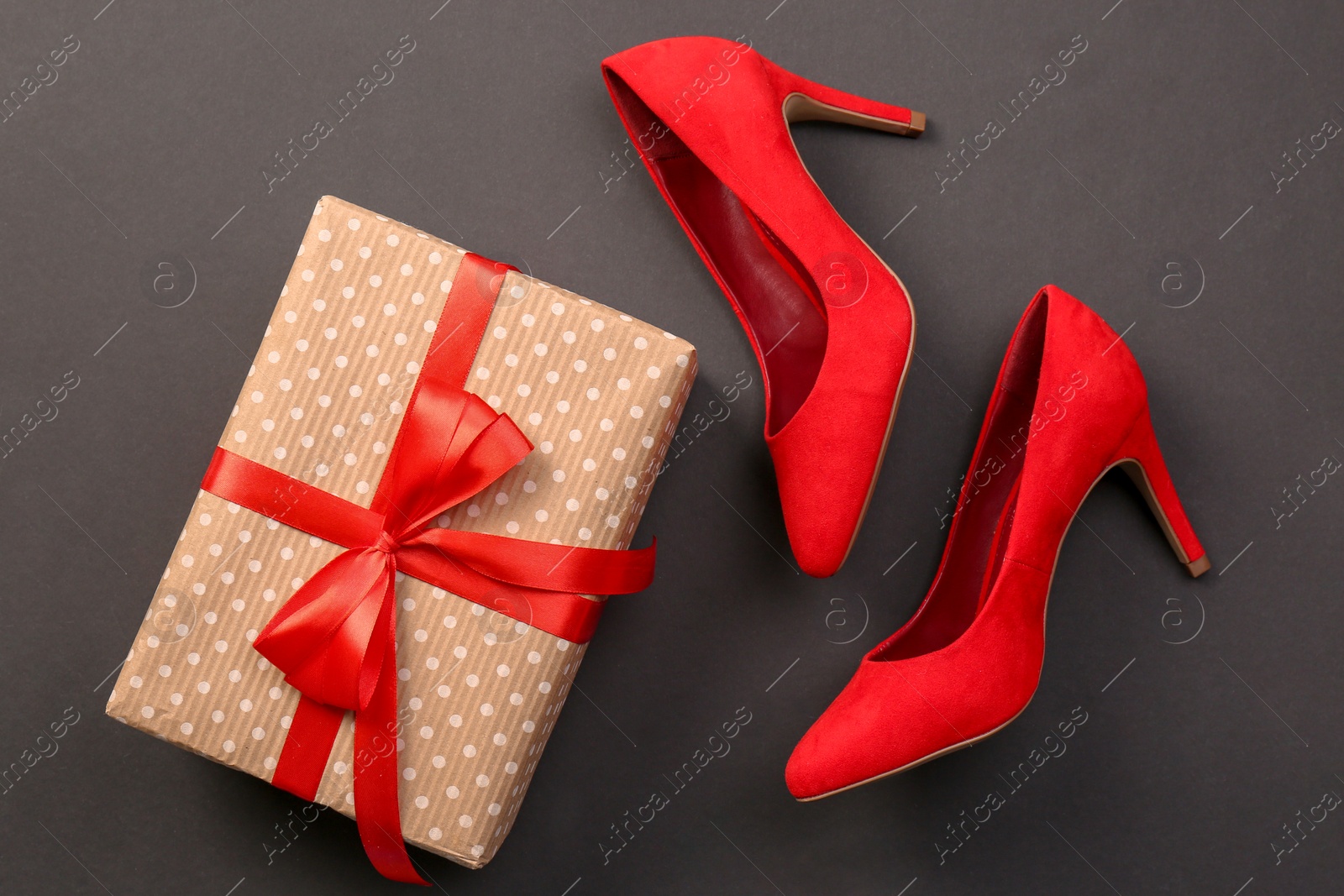 Photo of Elegant female shoes and gift box on dark background