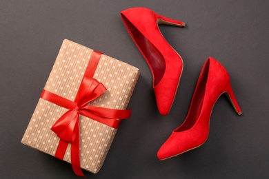 Photo of Elegant female shoes and gift box on dark background