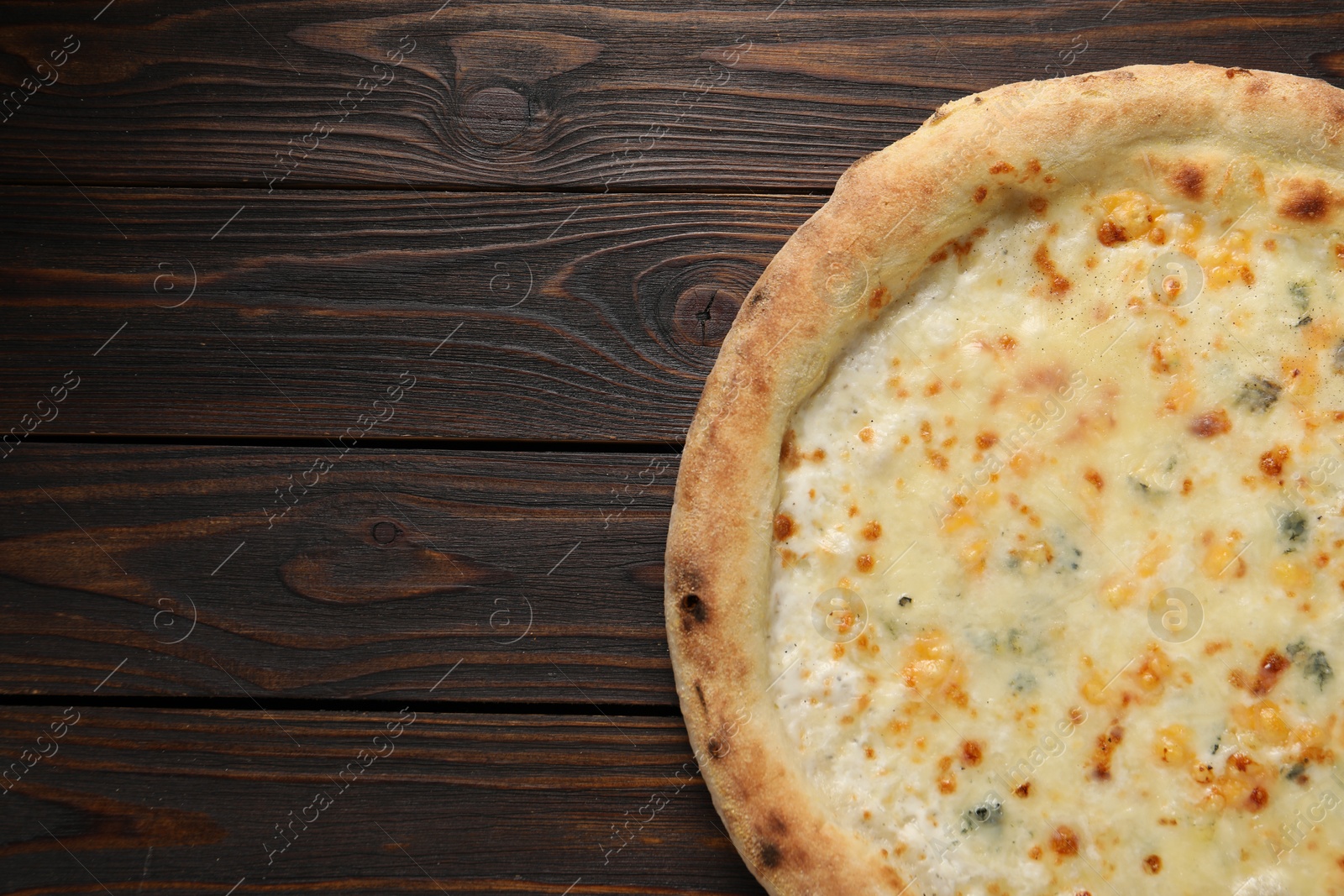 Photo of Delicious cheese pizza on wooden table, top view. Space for text