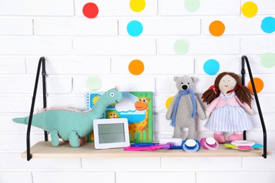 Baby accessories on shelf near white brick wall