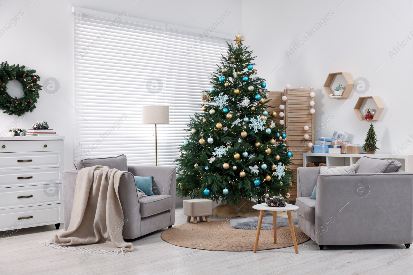 Photo of Christmas tree in room decorated for holiday. Festive interior design