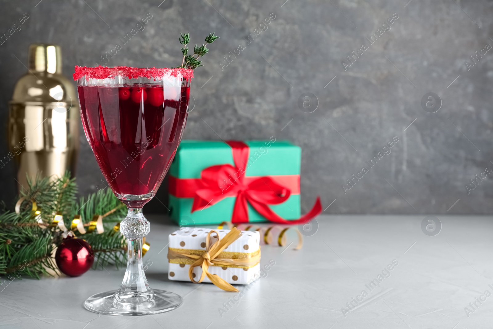 Photo of Delicious Christmas cocktail with liqueur on light table. Space for text