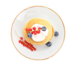 Tasty pancakes with natural yogurt, blueberries and red currants on white background, top view