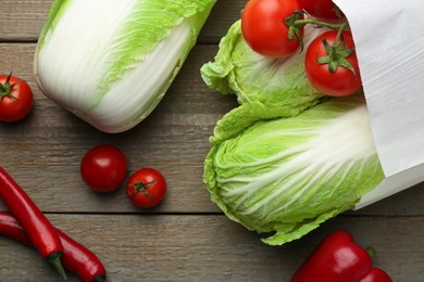 Fresh Chinese cabbages, tomatoes and peppers on wooden table, flat lay