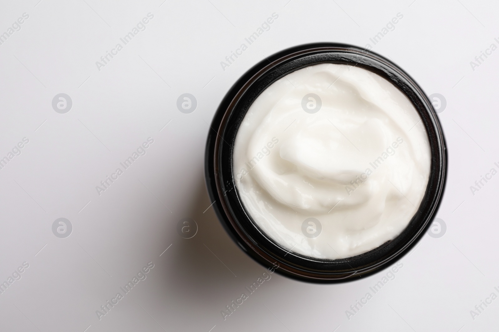 Photo of Jar of face cream on white background, top view. Space for text