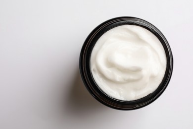Photo of Jar of face cream on white background, top view. Space for text