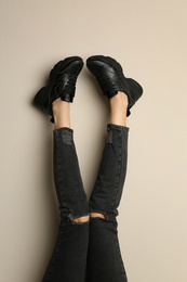 Photo of Woman wearing sneakers on beige background, closeup