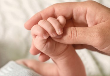 Mother and her newborn baby on bed, closeup view