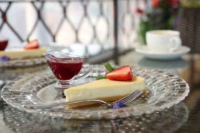 Photo of Slice of delicious cheesecake with strawberry served on table in restaurant, closeup. Space for text