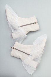 Photo of Women's boots in shoe covers on grey background, top view