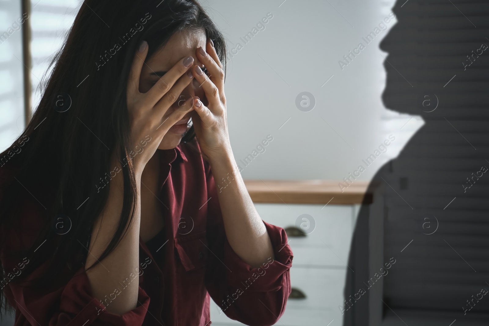 Image of Suffering from hallucination. Scared woman having panic attack because of man's shadow