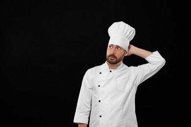 Photo of Thoughtful mature chef on black background, space for text