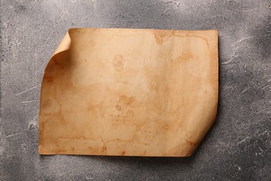 Sheet of old parchment paper on gray textured table, top view