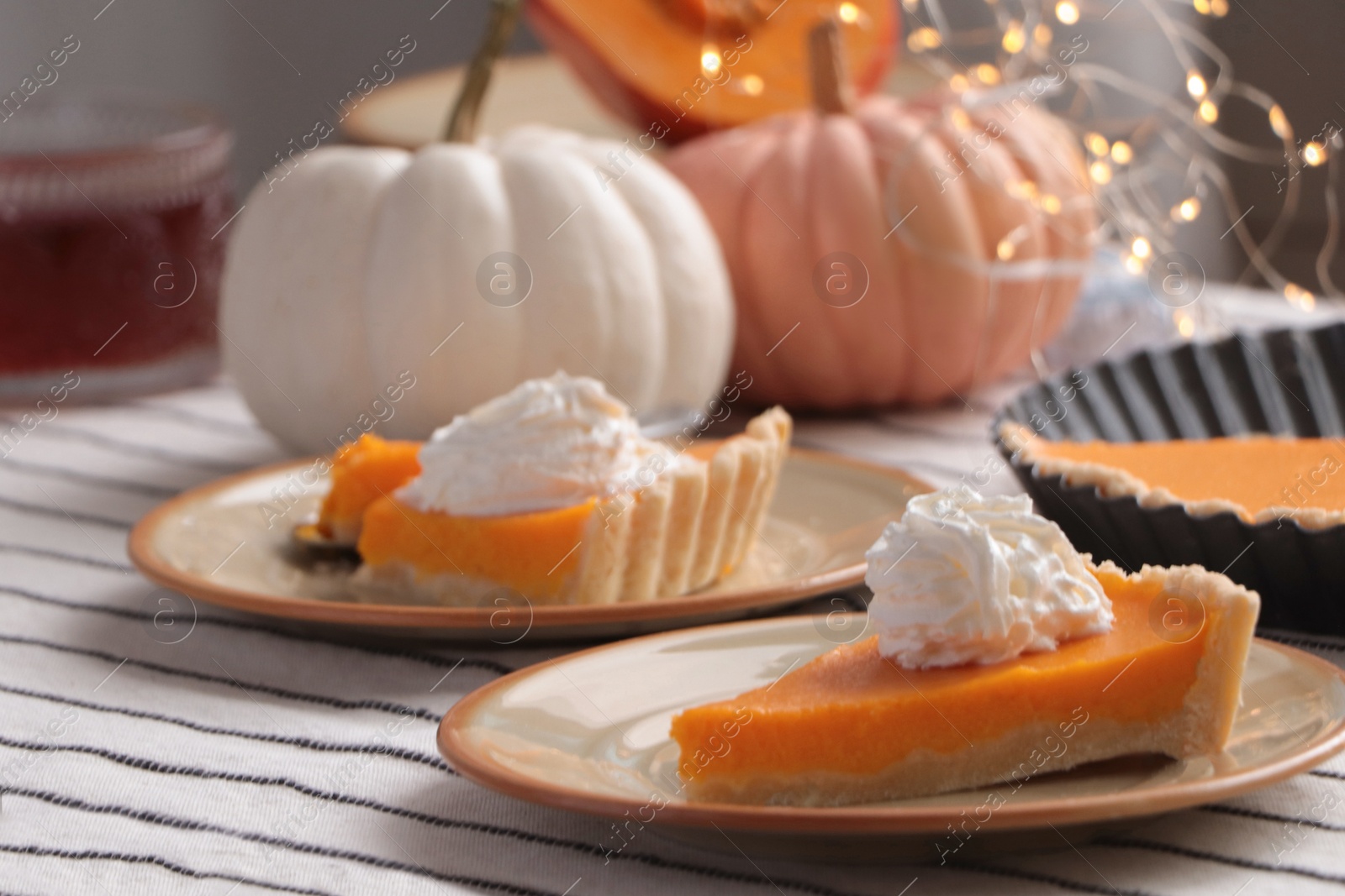 Photo of Fresh homemade pumpkin pie with whipped cream on table