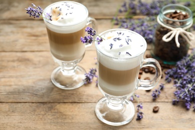 Delicious latte with lavender and coffee beans on wooden table