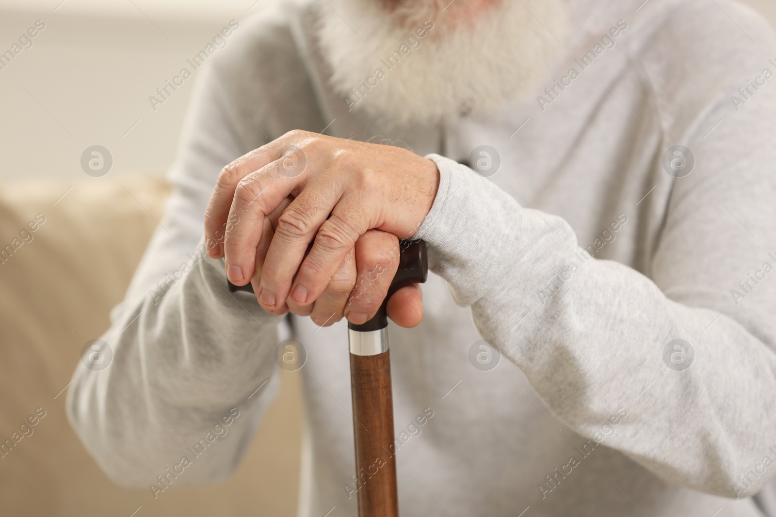 Photo of Senior man with walking cane indoors, closeup