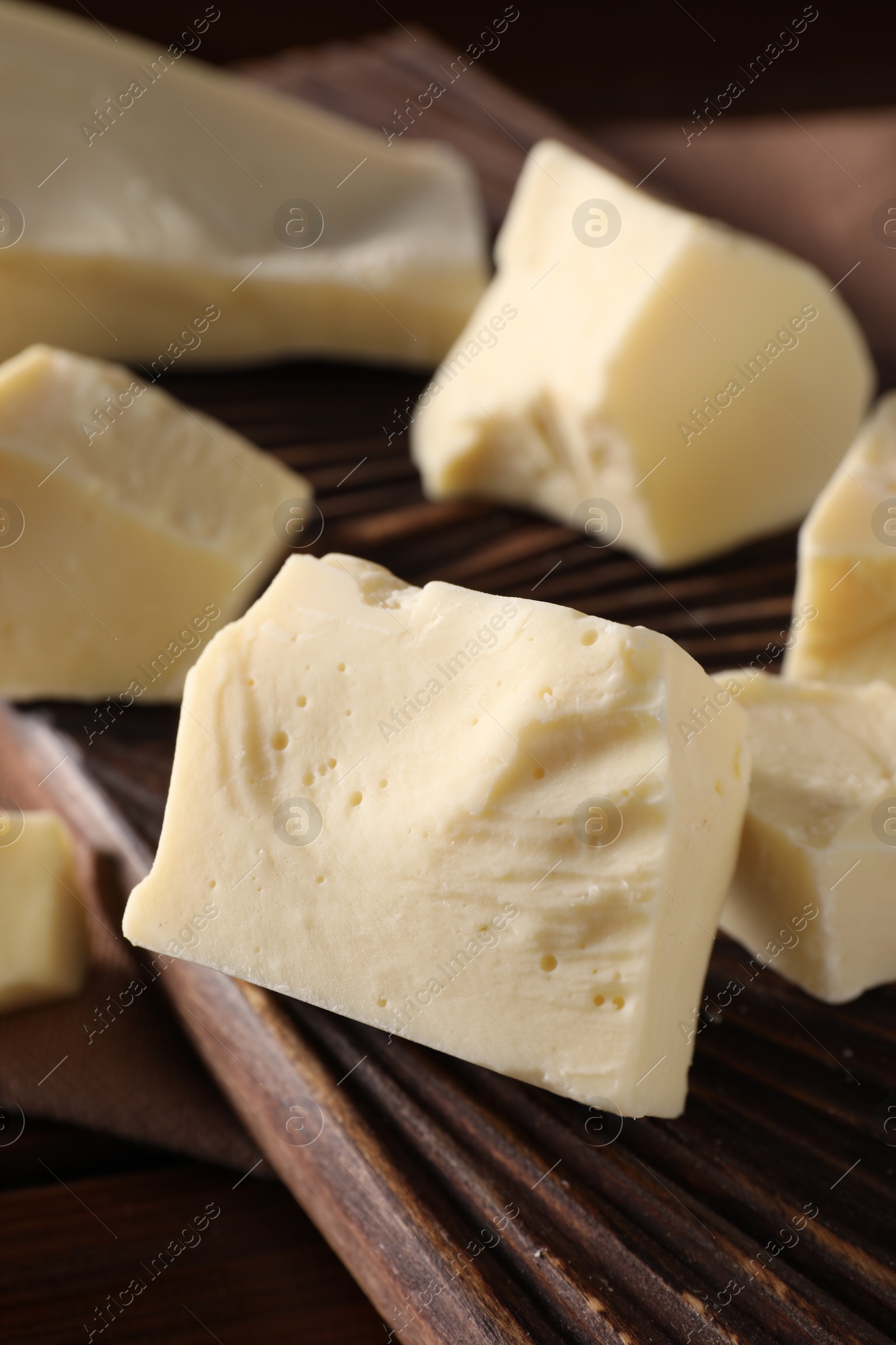 Photo of Pieces of tasty white chocolate on table, closeup