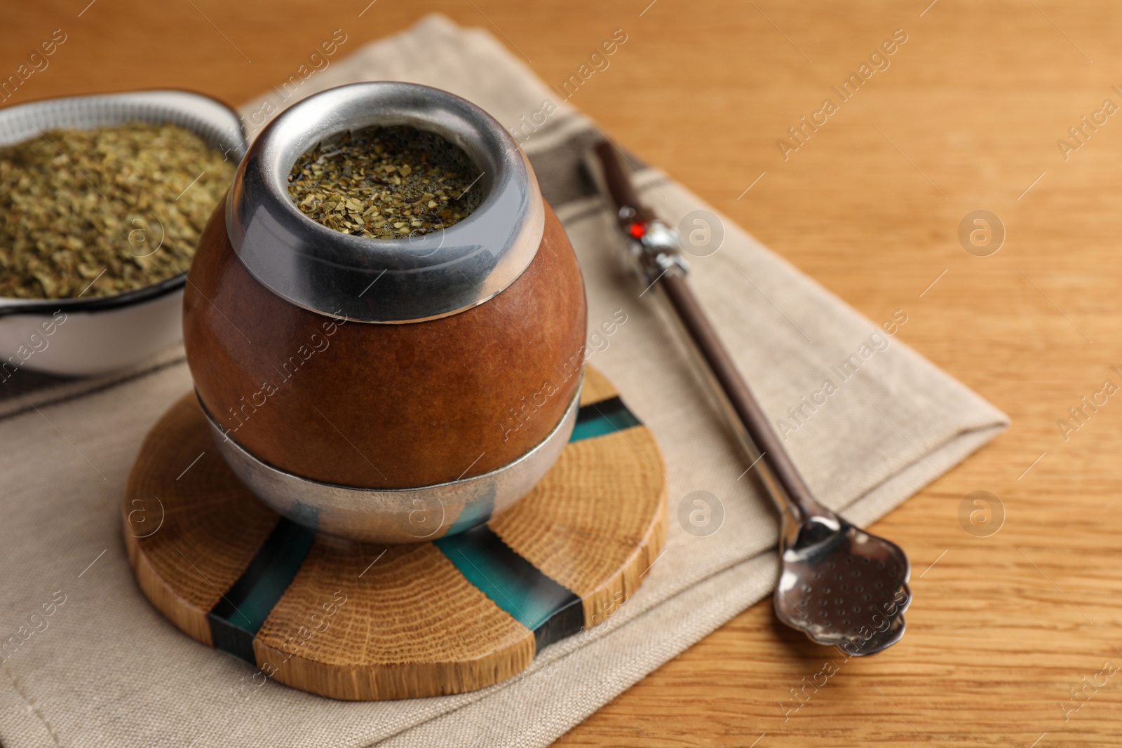 Photo of Calabash with mate tea and bombilla on wooden table