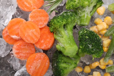 Photo of Different frozen vegetables on ice, flat lay
