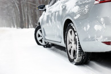Photo of Car with winter tires on snowy road outdoors, space for text