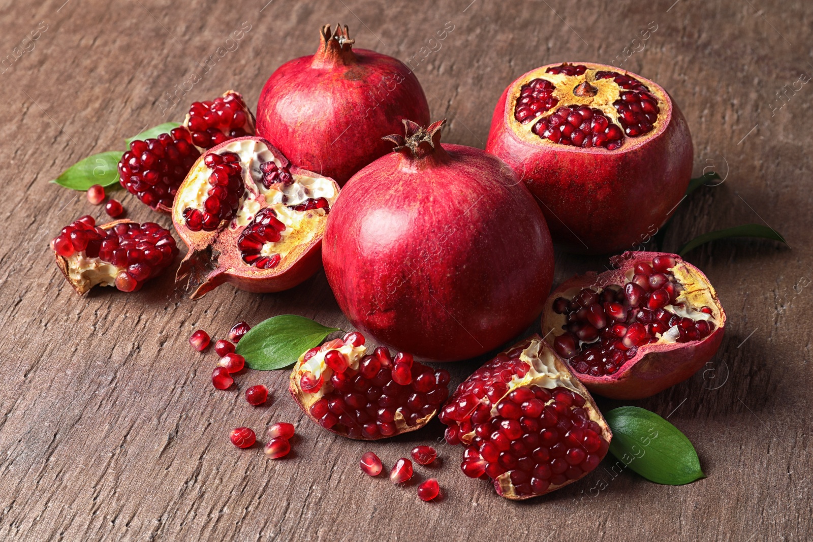 Photo of Composition with ripe pomegranates and leaves on color background