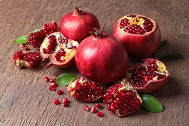 Photo of Composition with ripe pomegranates and leaves on color background