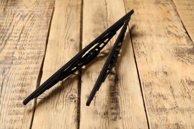 Pair of car windshield wipers on wooden background