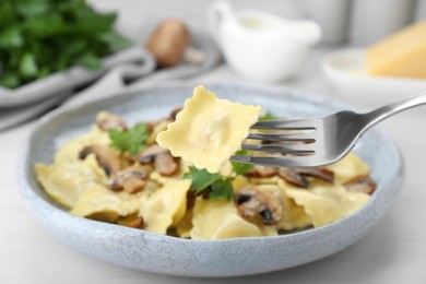 Photo of Eating delicious ravioli at white table, closeup