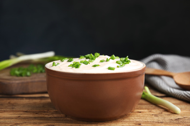 Fresh sour cream with onion on wooden table