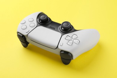 Photo of One wireless game controller on yellow background