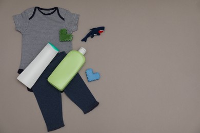 Bottles of laundry detergents, baby clothes, toy shark and decorative hearts on grey background, flat lay. Space for text