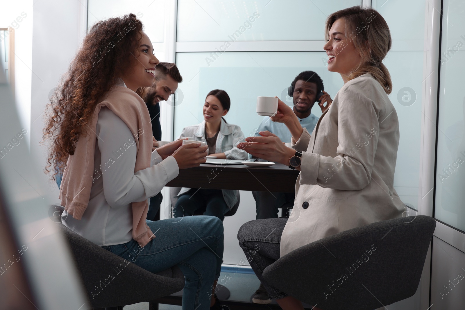 Photo of Team of employees enjoying coffee break together in office. Startup project