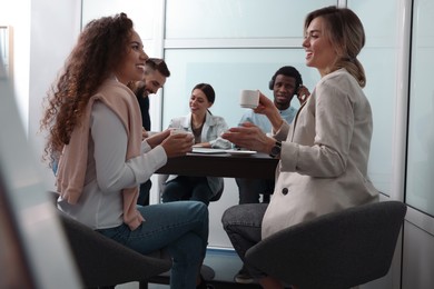 Photo of Team of employees enjoying coffee break together in office. Startup project