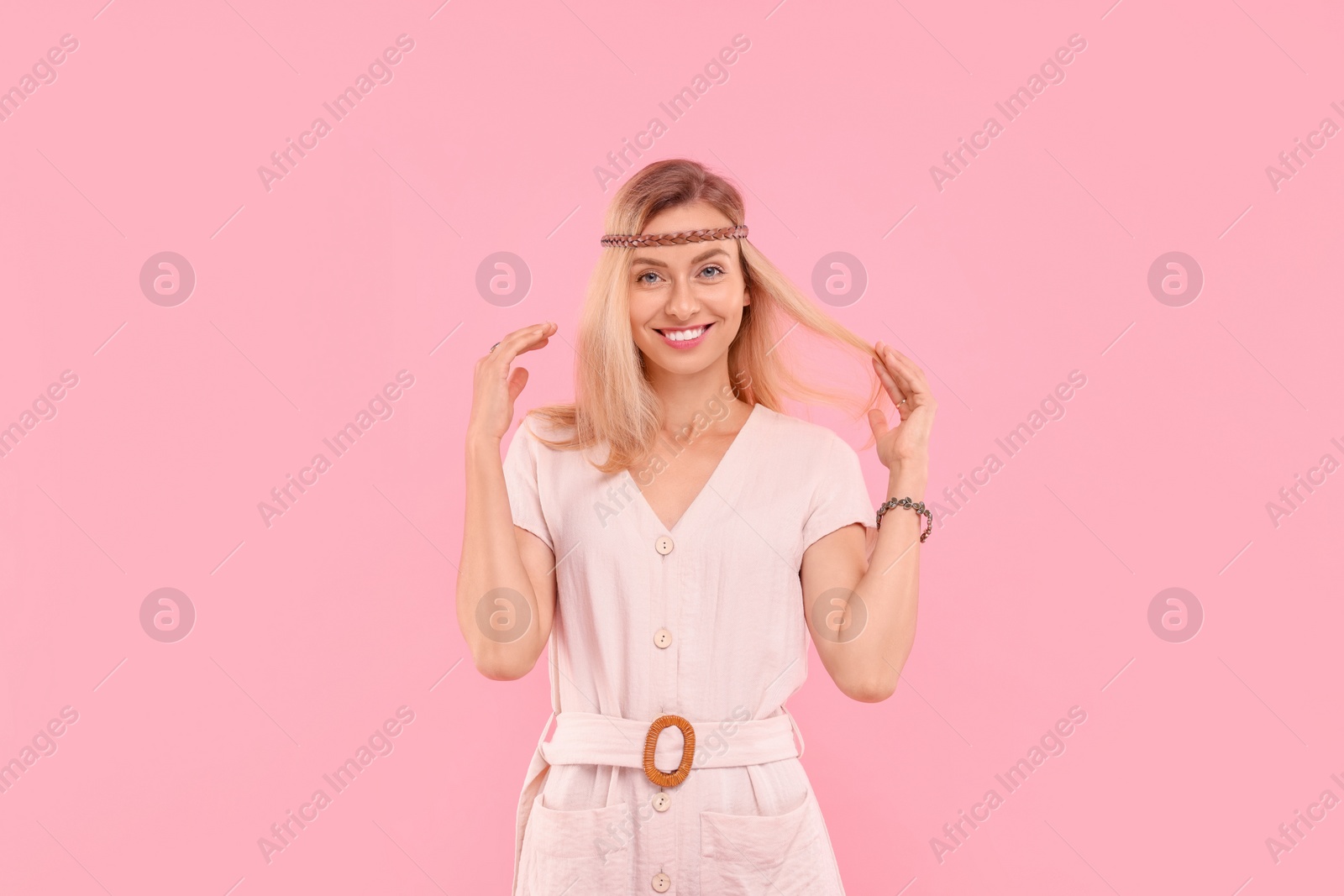 Photo of Portrait of happy hippie woman on pink background