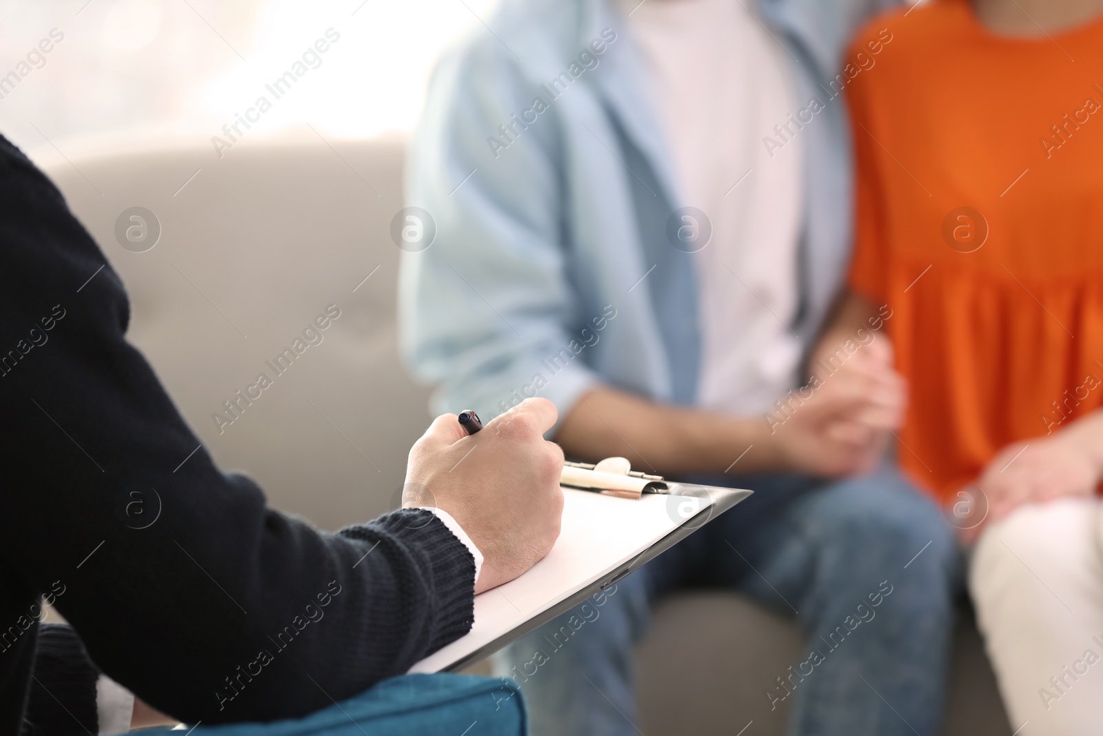 Photo of Family psychologist working with young couple in office, closeup