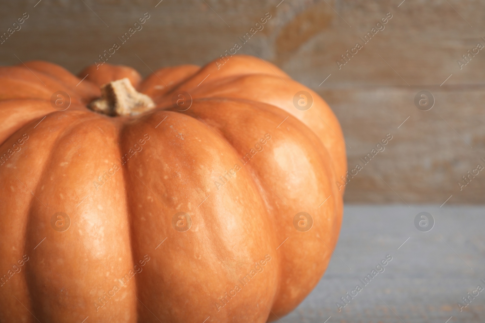 Photo of Fresh ripe pumpkin on wooden background, closeup