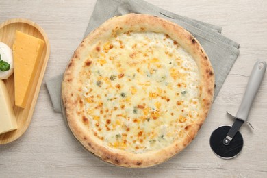 Delicious cheese pizza, cutter and different kinds of cheese on wooden table, flat lay