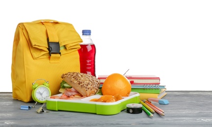 Composition with lunch box and food on table against white background