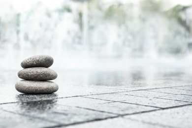 Stack of spa stones on wet city street, space for text