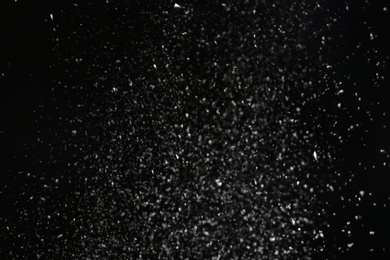 Photo of Snow flakes falling on black background. Winter weather