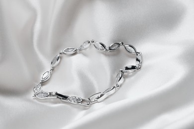 Beautiful bracelet with gemstones on white fabric. Luxury jewelry