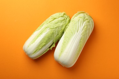 Photo of Fresh ripe Chinese cabbages on orange background, top view