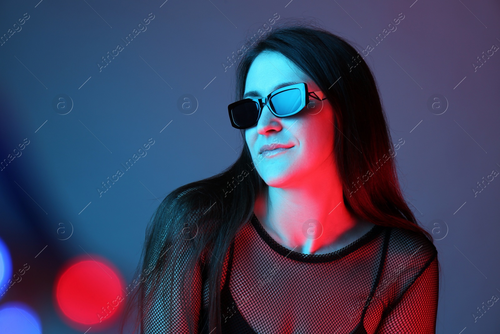 Photo of Portrait of beautiful young woman with sunglasses on color background