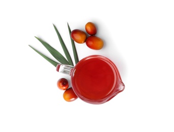 Photo of Palm oil in glass jug, tropical leaf and fruits isolated on white, top view